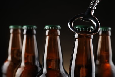 Opening bottle of beer on dark background, closeup