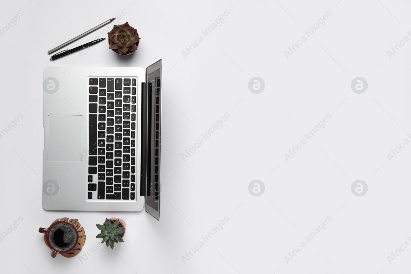 Photo of Modern laptop, houseplants and cup of coffee on white table, flat lay. Space for text