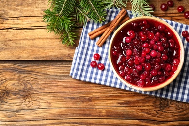 Photo of Flat lay composition with fresh cranberry sauce on wooden table, space for text