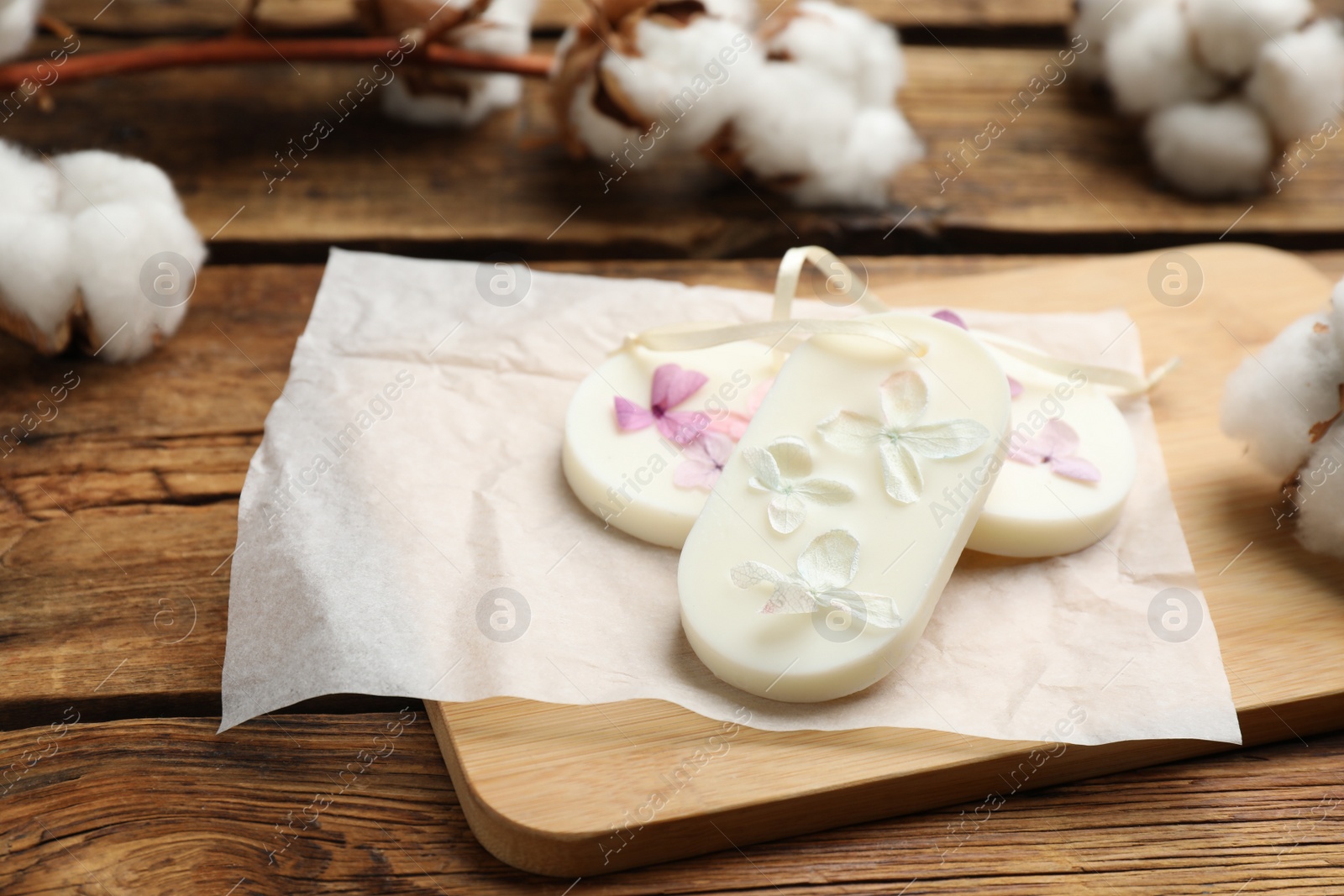 Photo of Scented sachets and cotton flowers on wooden table