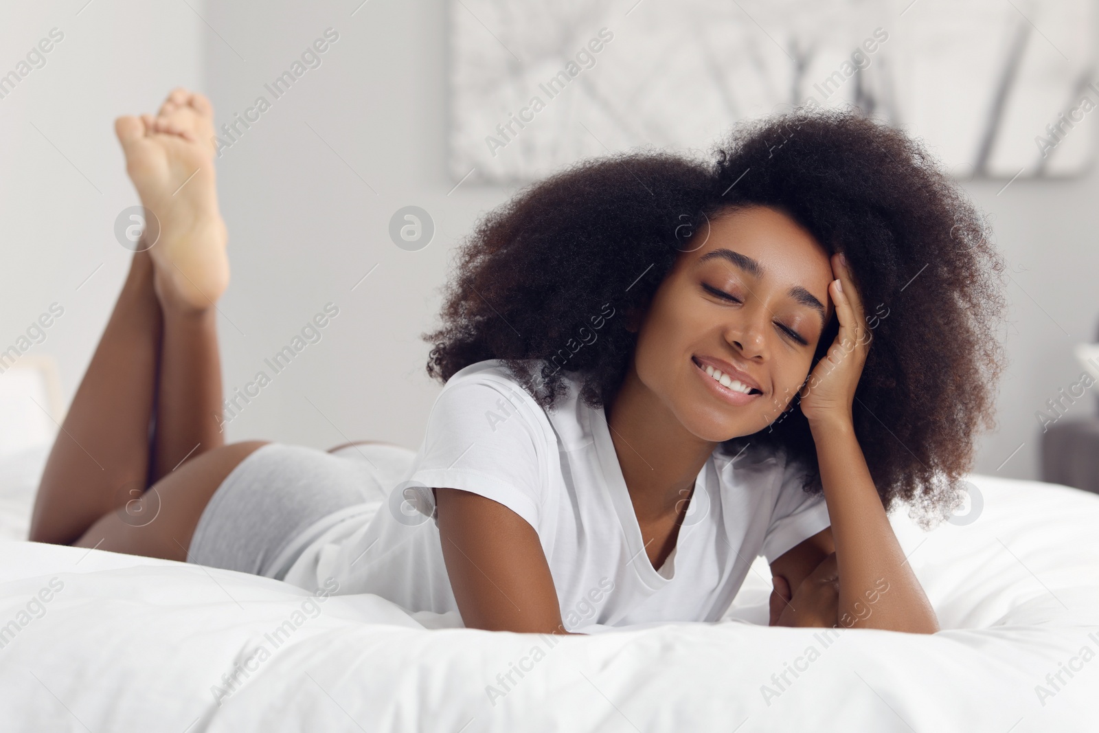 Photo of Beautiful woman in stylish underwear and t-shirt on bed indoors