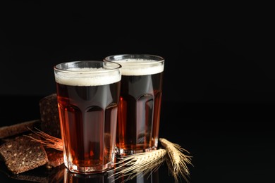 Photo of Delicious kvass, bread and spikes on black background. Space for text