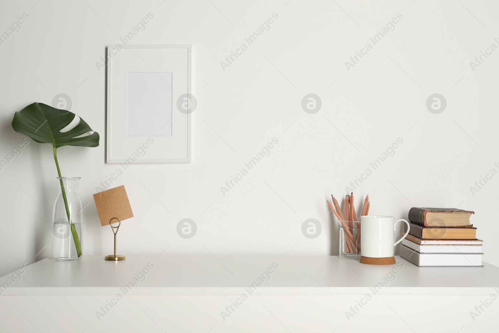 Photo of Comfortable workplace with white desk near wall at home