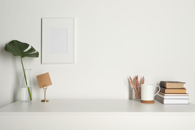 Photo of Comfortable workplace with white desk near wall at home