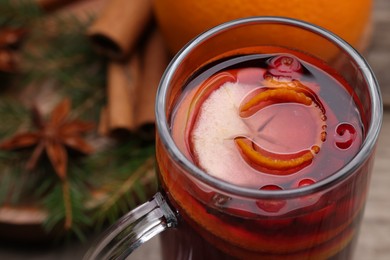 Aromatic mulled wine in glass cup on table, closeup. Space for text