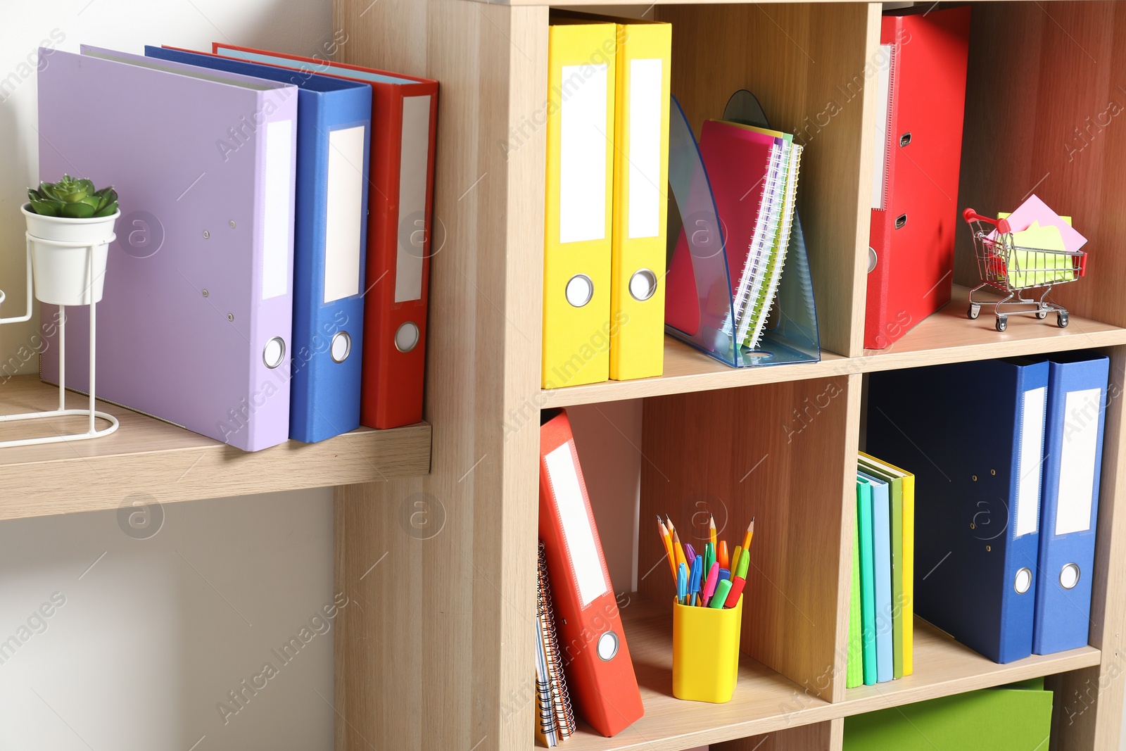 Photo of Colorful binder office folders and other stationery on shelving unit