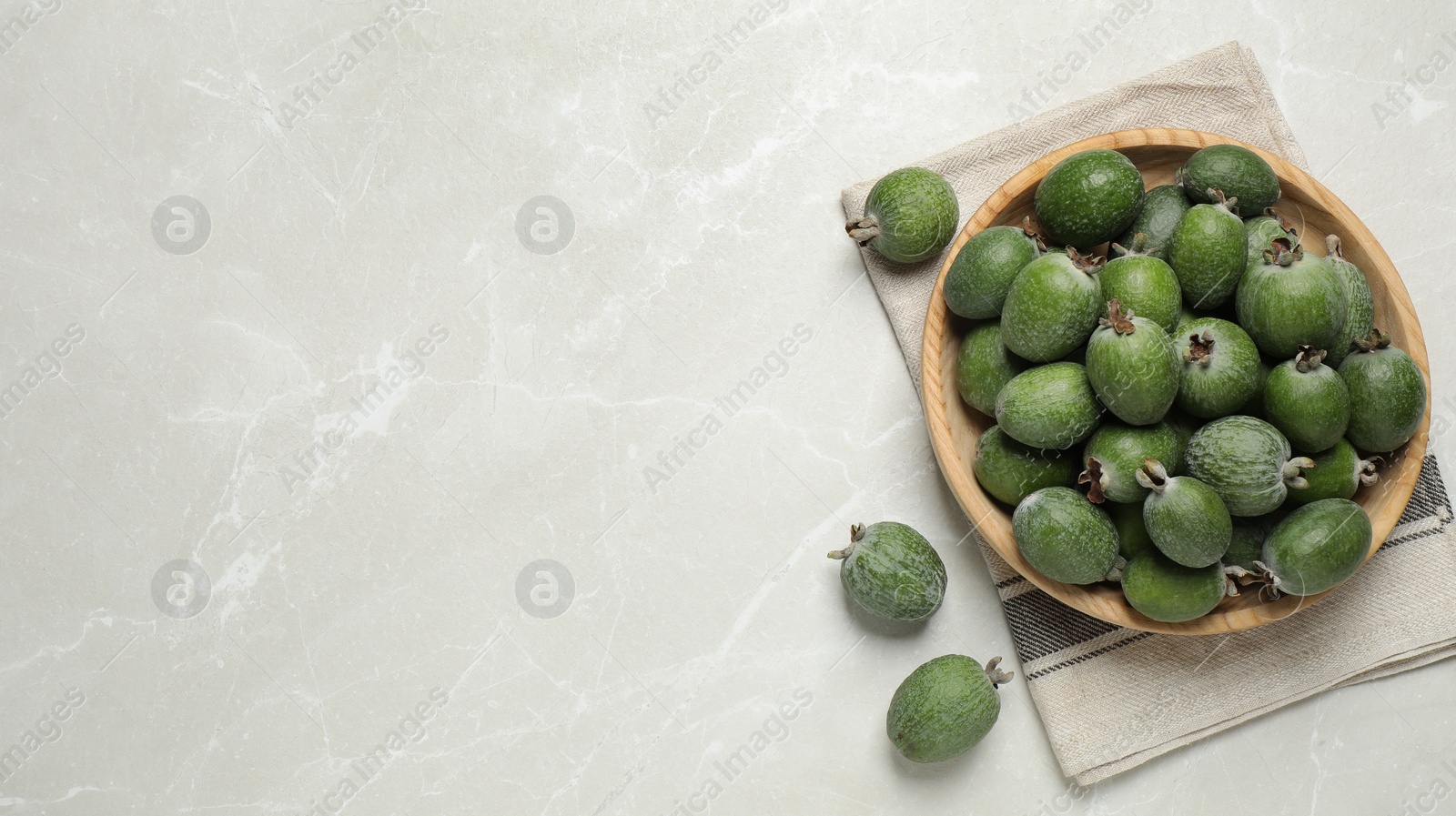 Image of Fresh green feijoa fruits on light grey marble table, flat lay with space for text. Banner design