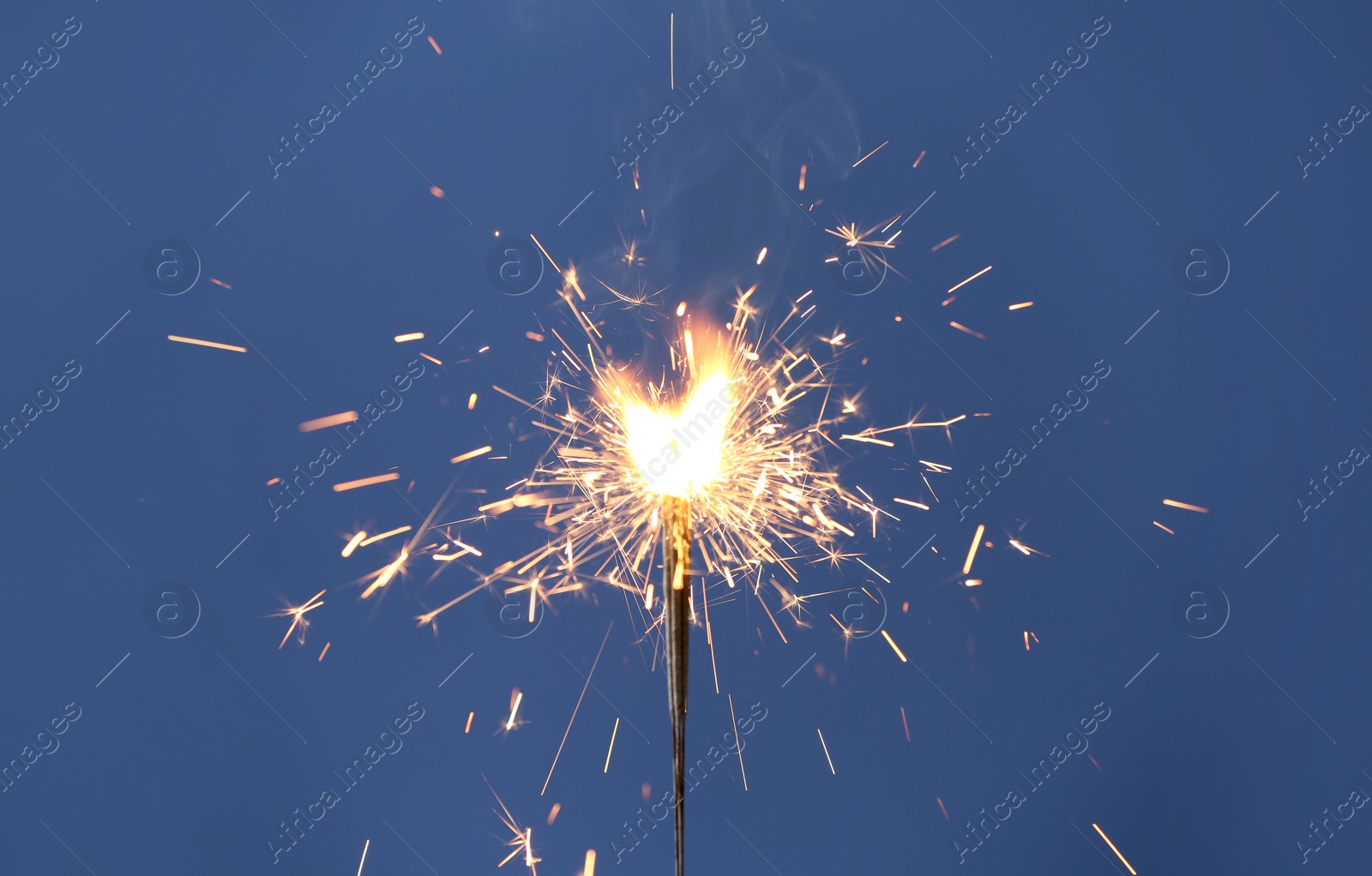 Photo of Beautiful sparklers burning on blue background. Party decor