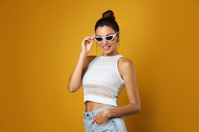 Photo of Beautiful woman in sunglasses on yellow background