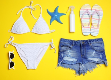 Flat lay composition with stylish bikini on color background. Beach objects