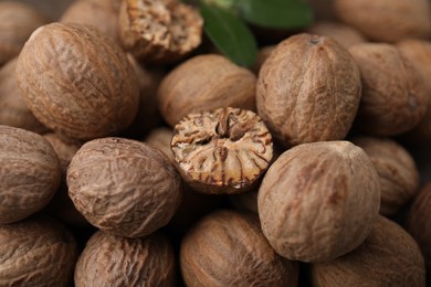Photo of Whole and cut nutmegs as background, closeup