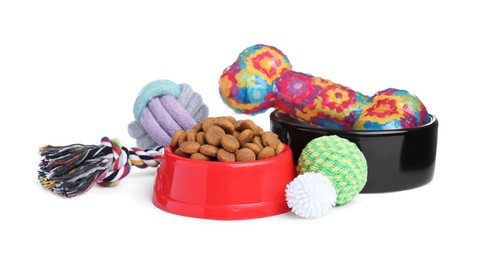 Photo of Feeding bowls and toys for pet on white background