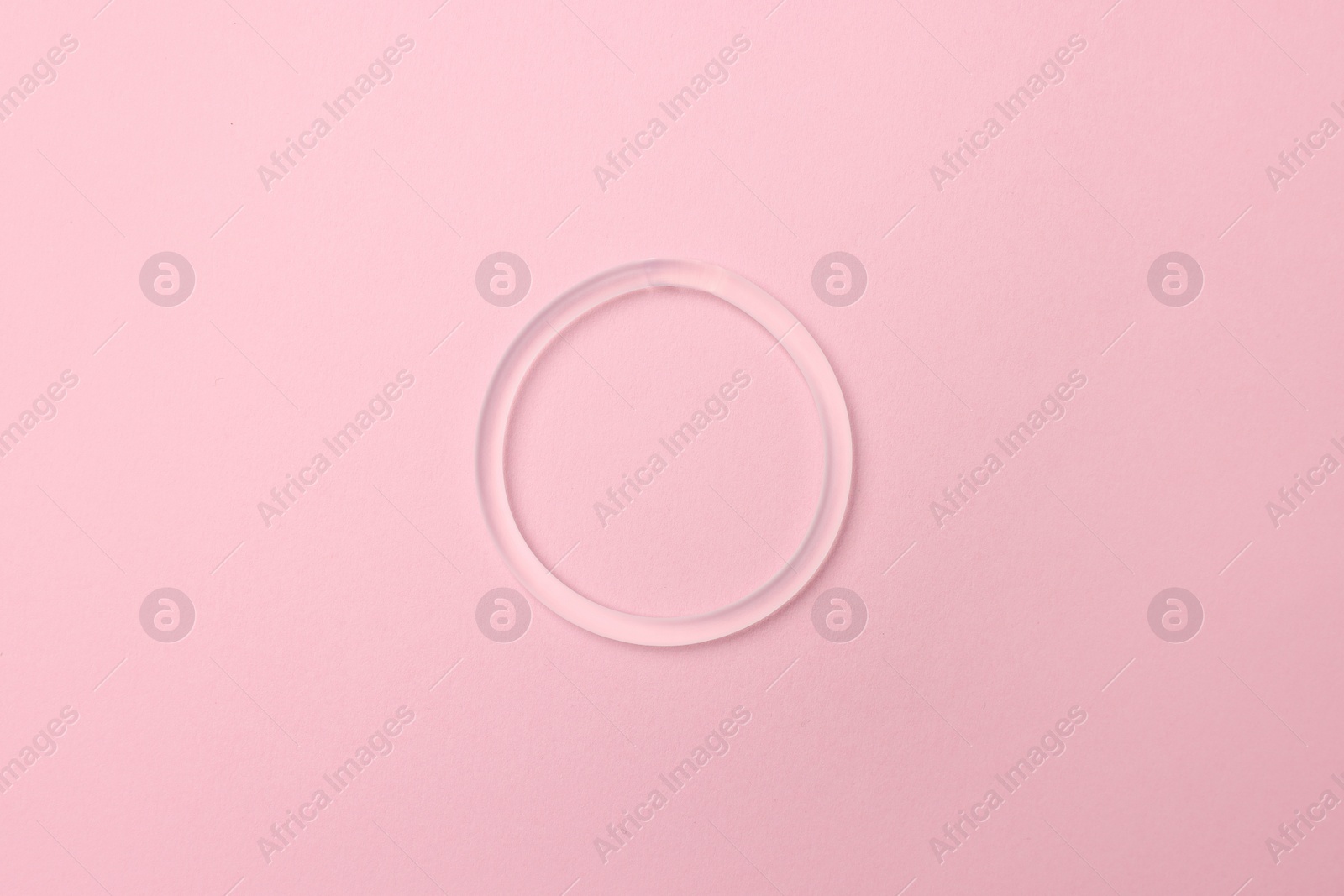 Photo of Diaphragm vaginal contraceptive ring on pink background, top view