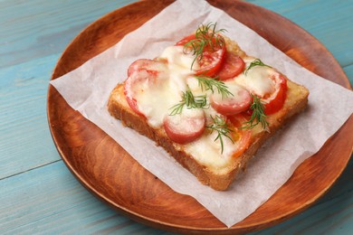 Photo of Tasty pizza toast with cheese, tomato and dill on light blue wooden table, closeup
