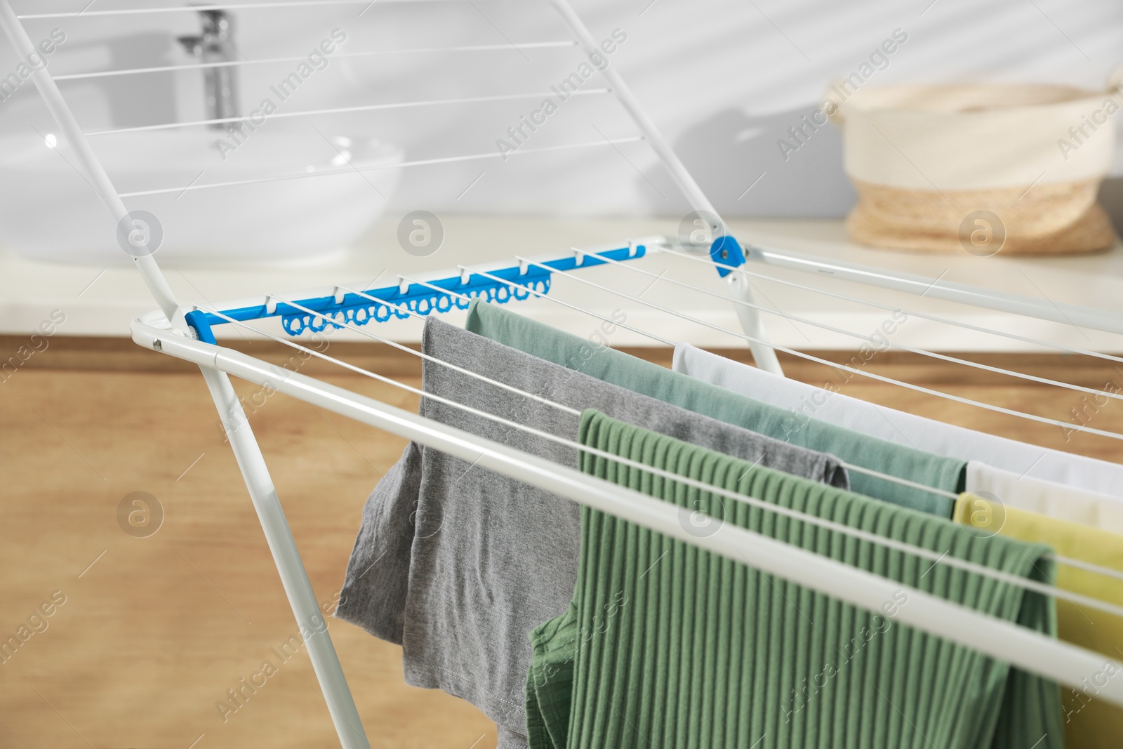 Photo of Different apparel drying on clothes airer in bathroom