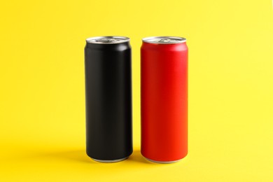 Photo of Energy drinks in colorful cans on yellow background