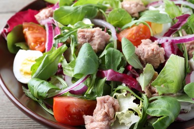 Photo of Bowl of delicious salad with canned tuna and vegetables on table, closeup