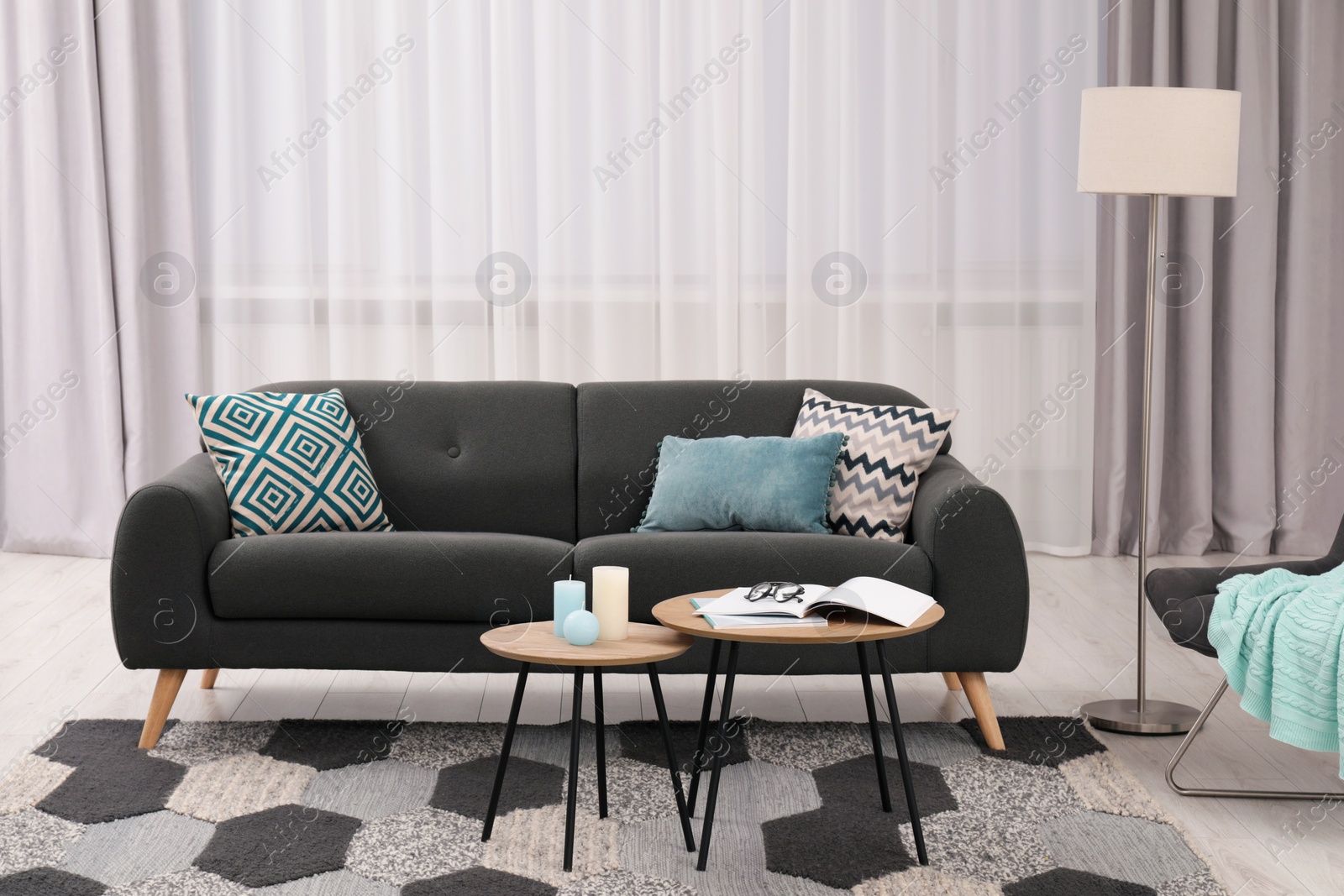 Photo of Comfortable sofa, floor lamp and coffee table in stylish room. Interior design