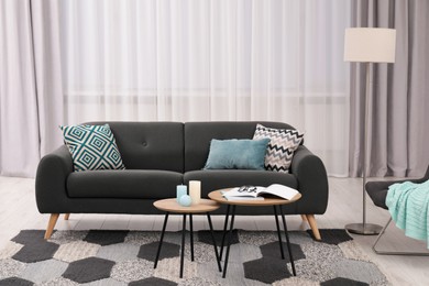 Comfortable sofa, floor lamp and coffee table in stylish room. Interior design