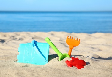 Photo of Set of plastic beach toys on sand near sea