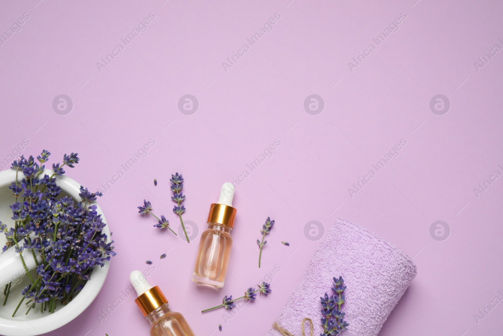Photo of Flat lay composition with lavender flowers and natural essential oil on pink background. Space for text