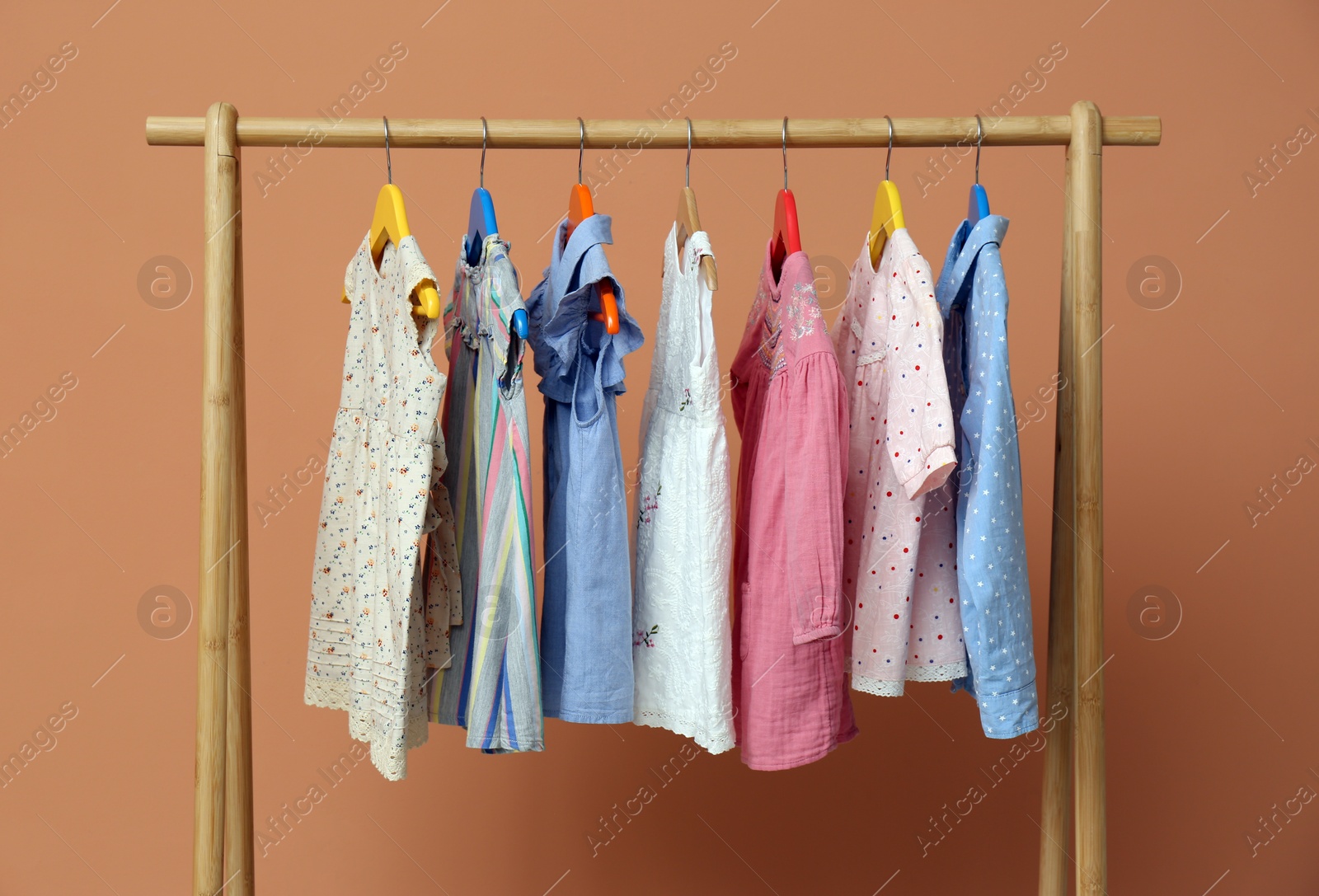 Photo of Rack with stylish children clothes on beige background