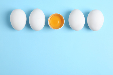 Photo of Fresh raw chicken eggs on light blue background, flat lay. Space for text