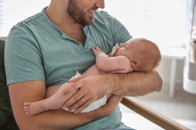 Photo of Father with his newborn son at home, closeup