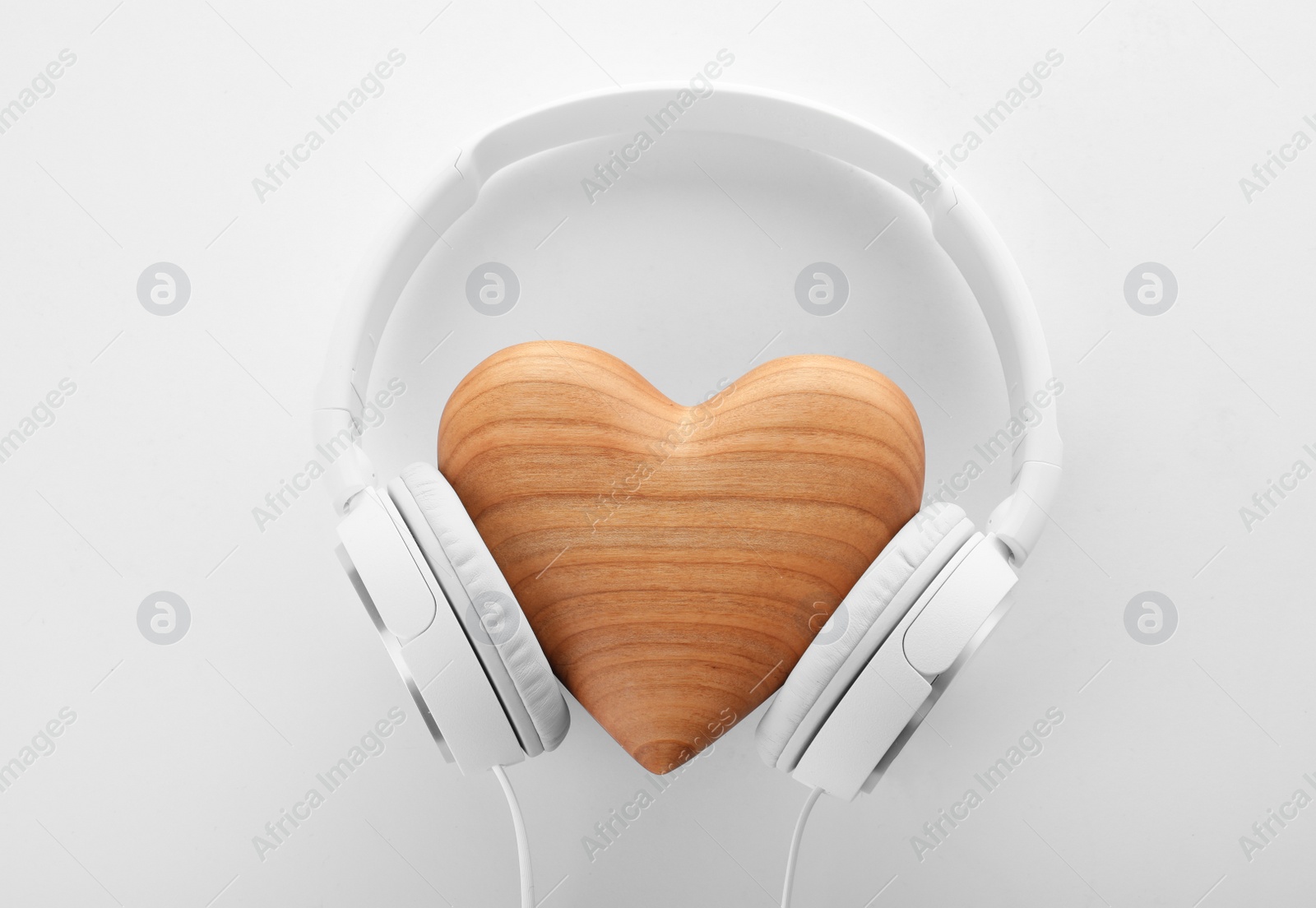 Photo of Headphones and wooden heart on white background, top view