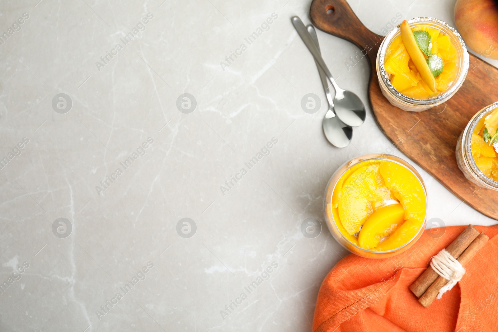 Photo of Tasty peach dessert with yogurt served on light table, flat lay. Space for text