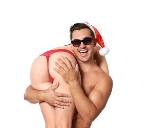 Photo of Attractive young Santa Claus with sexy woman on white background