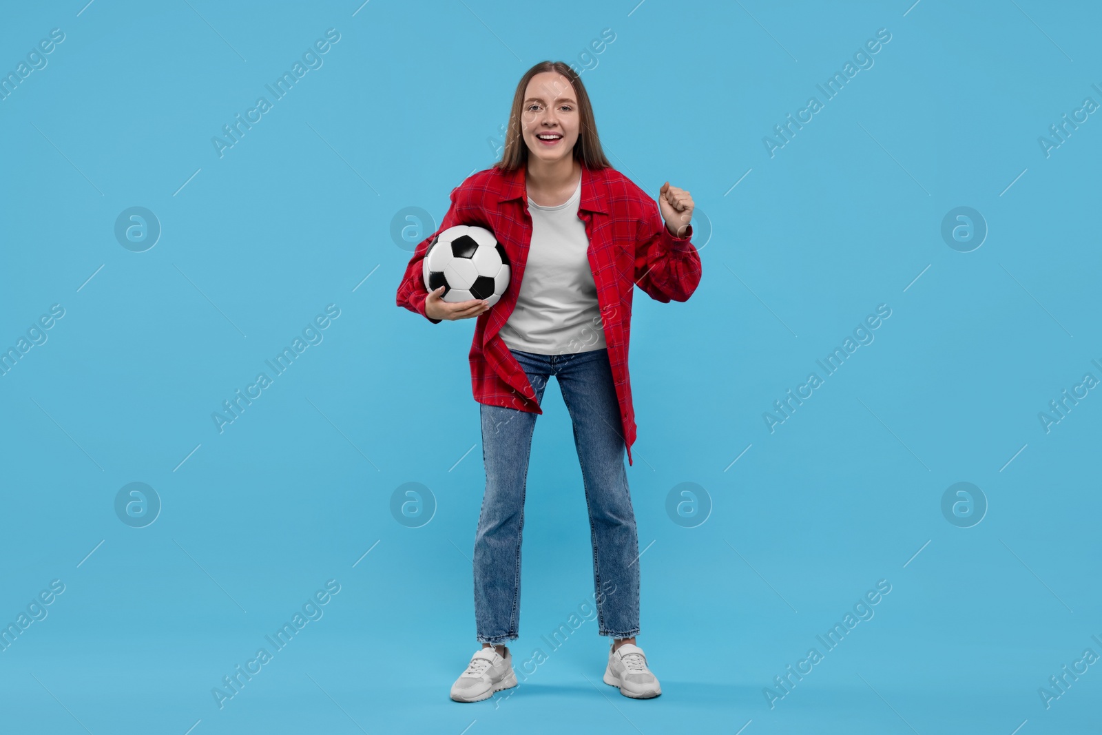 Photo of Emotional sports fan with ball on light blue background