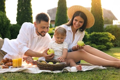 Happy family having picnic in garden on sunny day