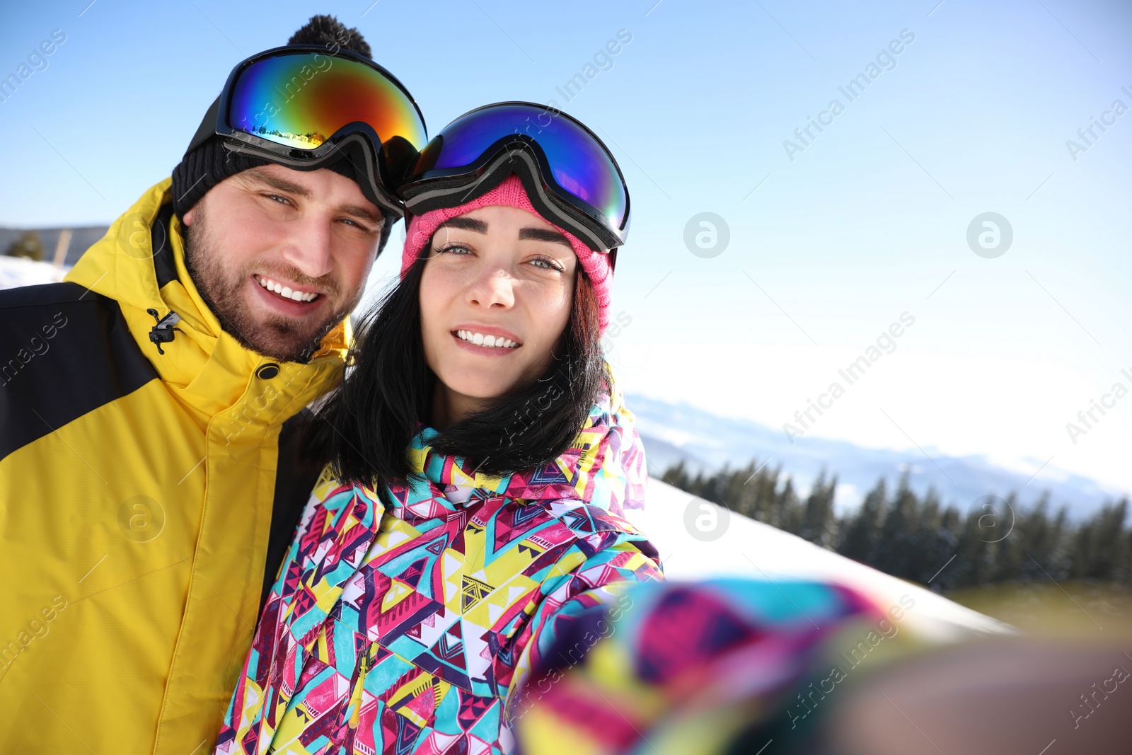 Photo of Young couple taking selfie at ski resort. Winter vacation