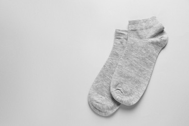 Pair of socks on light grey background, flat lay. Space for text