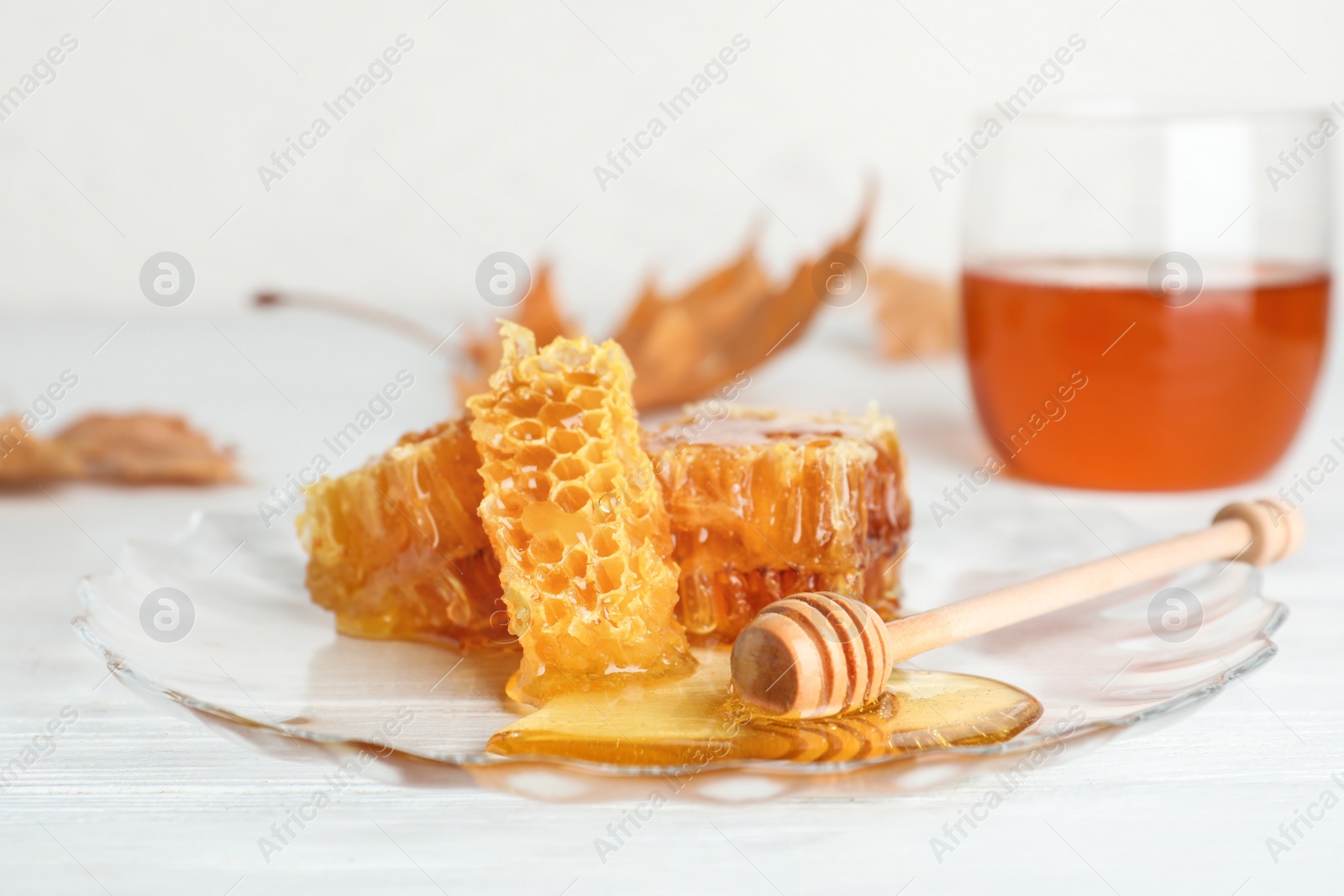 Photo of Plate with honeycomb pieces and dipper on table