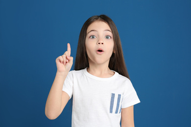 Portrait of cute little girl on blue background