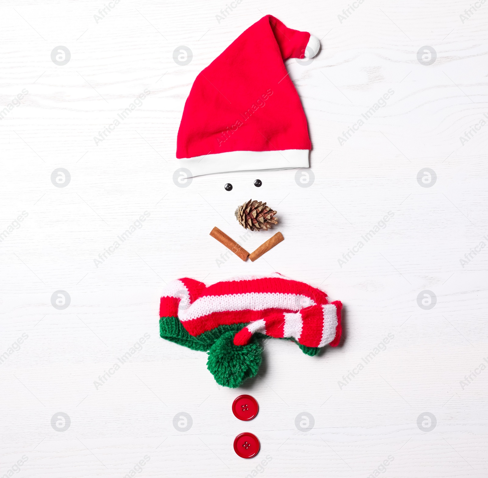 Photo of Funny snowman made with different elements on white wooden background, flat lay