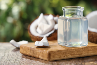 Photo of Coconut oil on wooden table against blurred background