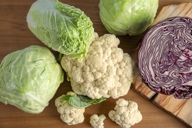 Photo of Flat lay composition with different cabbages on wooden background