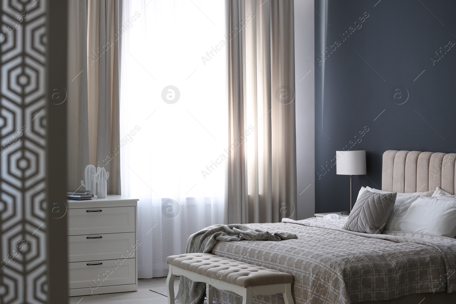 Photo of Beautiful curtains on window in stylish bedroom interior