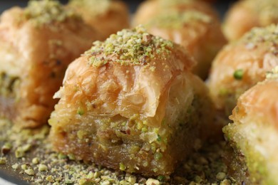 Photo of Delicious fresh baklava with chopped nuts on plate, closeup. Eastern sweets