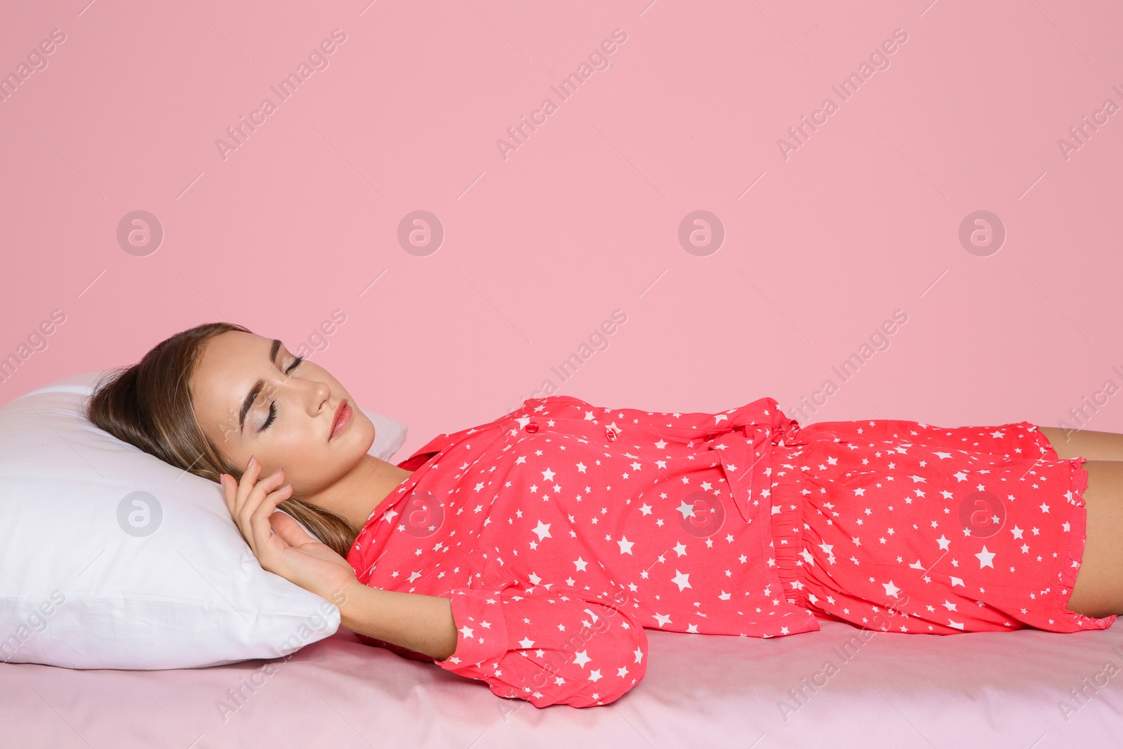 Photo of Beautiful teen girl sleeping with comfortable pillow on bed against color background. Space for text