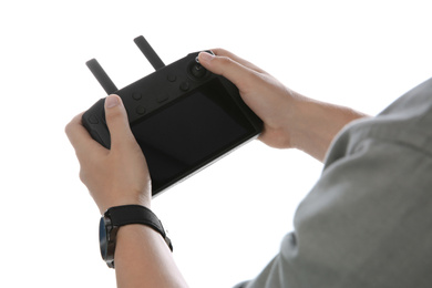 Man holding new modern drone controller on white background, closeup of hands