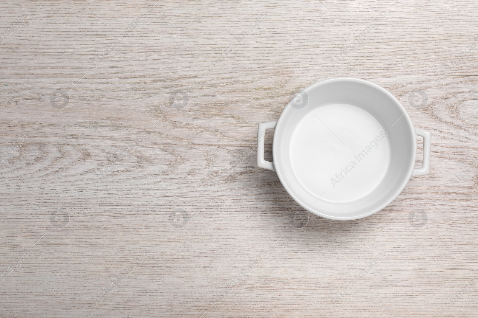 Photo of One empty pot on white wooden table, top view. Space for text