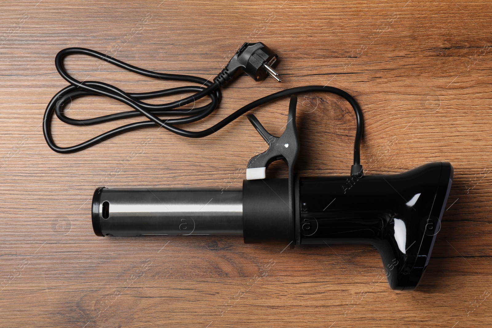 Photo of Thermal immersion circulator on wooden table, top view. Sous vide cooker