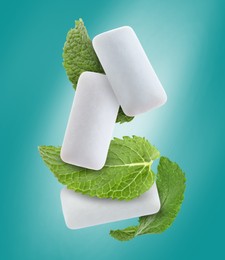 Image of Fresh mint leaves and chewing gum pads falling on turquoise background