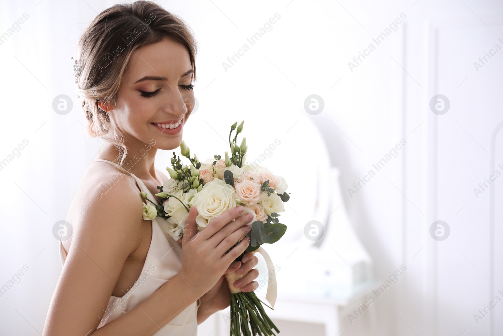 Photo of Young bride with beautiful wedding bouquet in room. Space for text