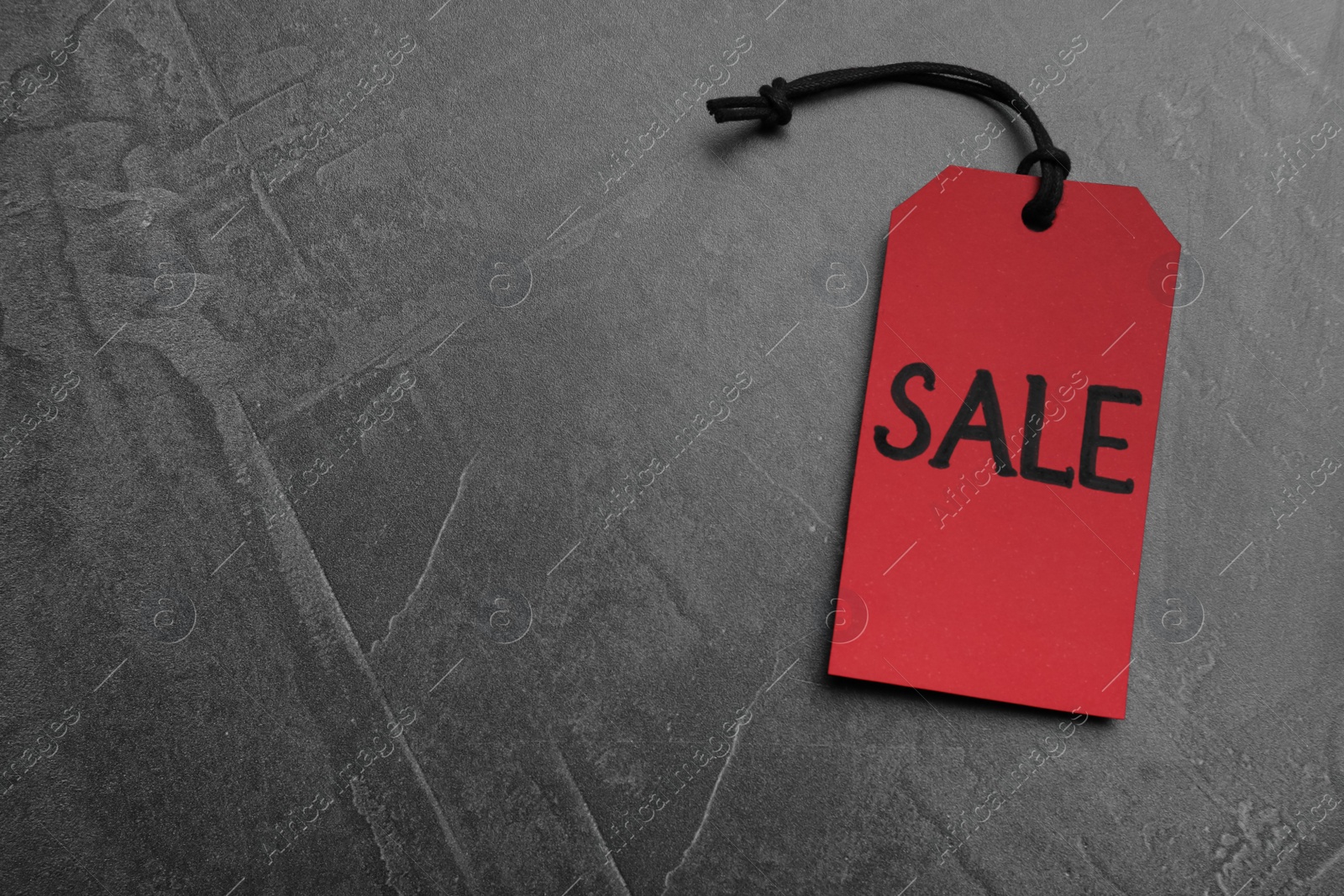 Photo of Red tag with word Sale on grey table, top view and space for text. Black Friday