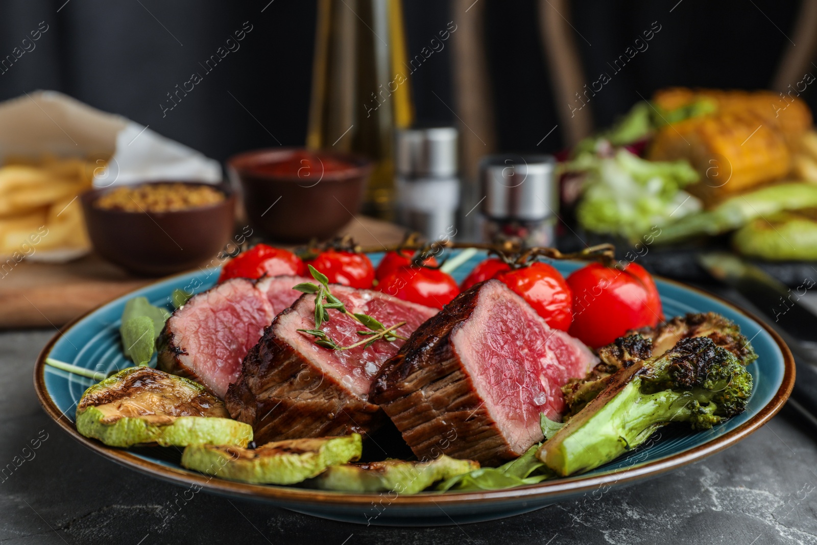 Photo of Delicious sliced beef steak served on grey table, closeup